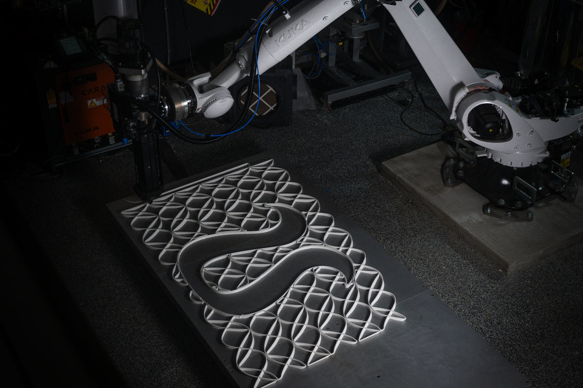 Wide view of a KUKA robotic arm producing a lululemon-logo mesh panel for the Prudential Center installation at Decibel.