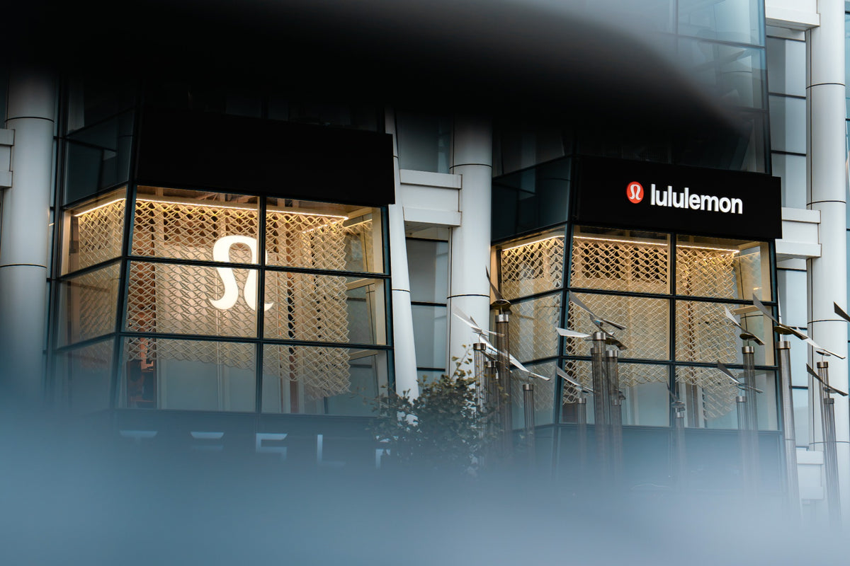 Two illuminated lululemon Prudential Center window bays with custom printed architectural mesh, seen through soft foreground depth in Boston.