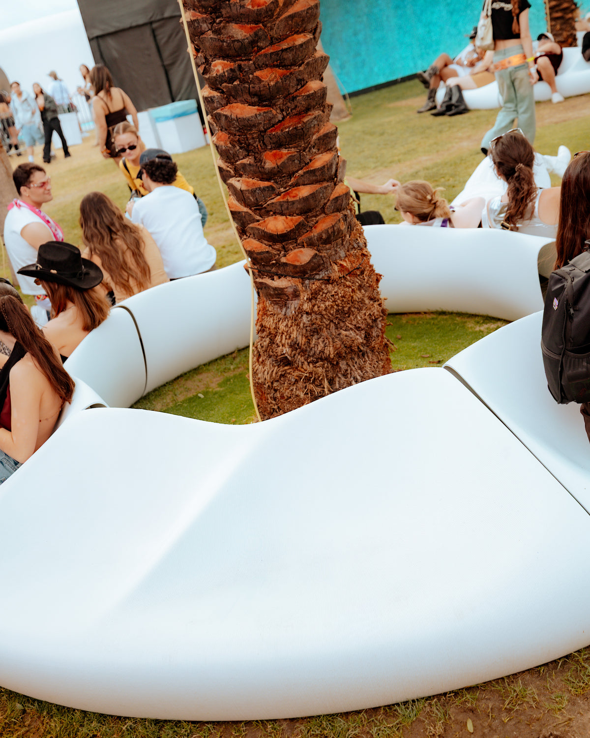 Detail of the smooth white seating surface around a palm tree at SKYLRK Coachella.