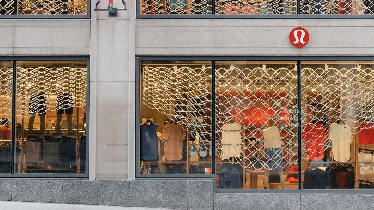 Architectural mesh spanning the ground-floor windows of lululemon’s Montréal flagship.