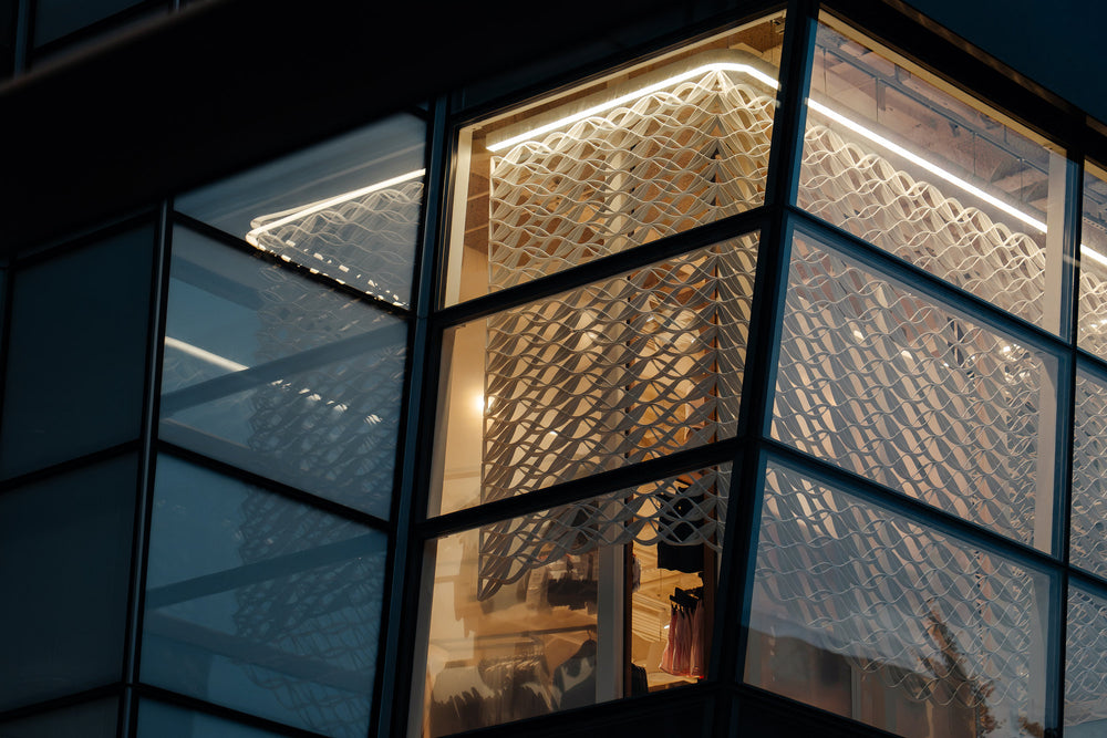 Architectural mesh turning the corner of a glass bay at lululemon’s Prudential Center store.