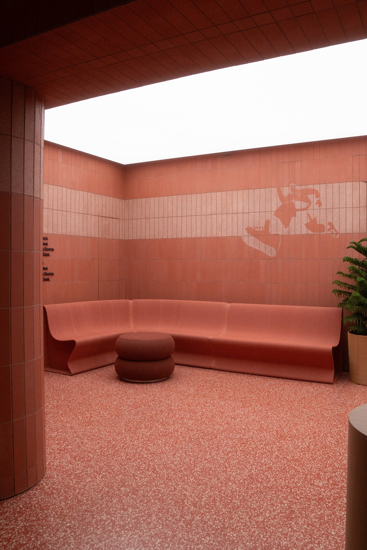 Red custom seating integrated into a tiled retail interior at lululemon’s SoHo flagship.