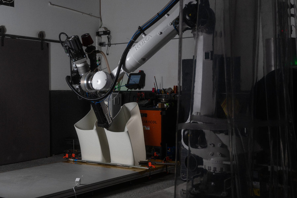 Wide view of robotic production of white sculptural SKYLRK seating components at Decibel.