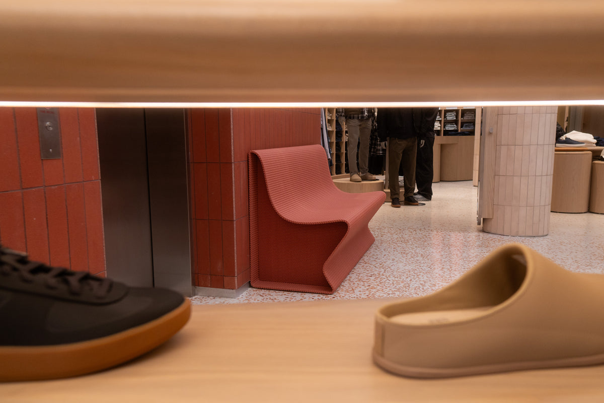 A custom red bench seen through a footwear display at lululemon SoHo.